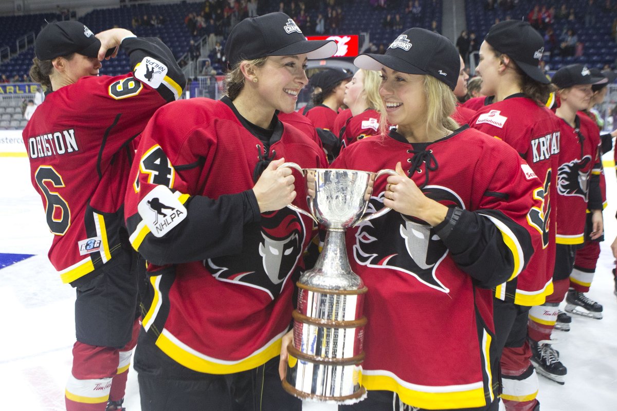 Calgary Inferno's Zoe Hickel (left) and Tori Hickel celebrate with the trophy after beating Les Canadiennes de Montreal 5-2 to win the 2019 Clarkson Cup game in Toronto on Sunday, March 24 , 2019. 