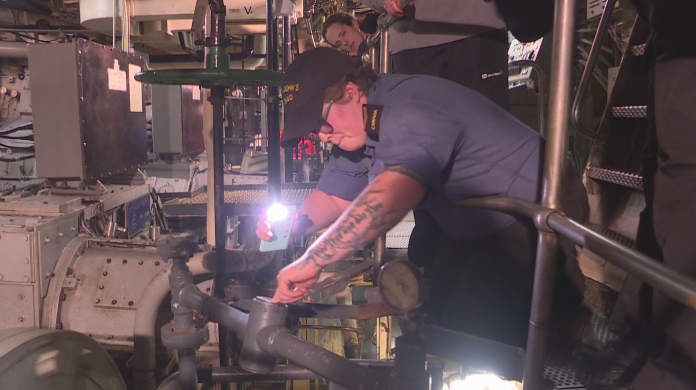 Lead Seaman Kara Vassallo checks on oil in the engine room.