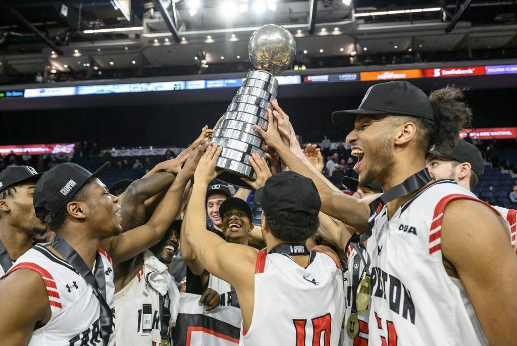 Members of the Carleton Ravens celebrate winning the USports men's basketball national championship over the University of Calgary Dinos in Halifax on Sunday, March 10, 2019.