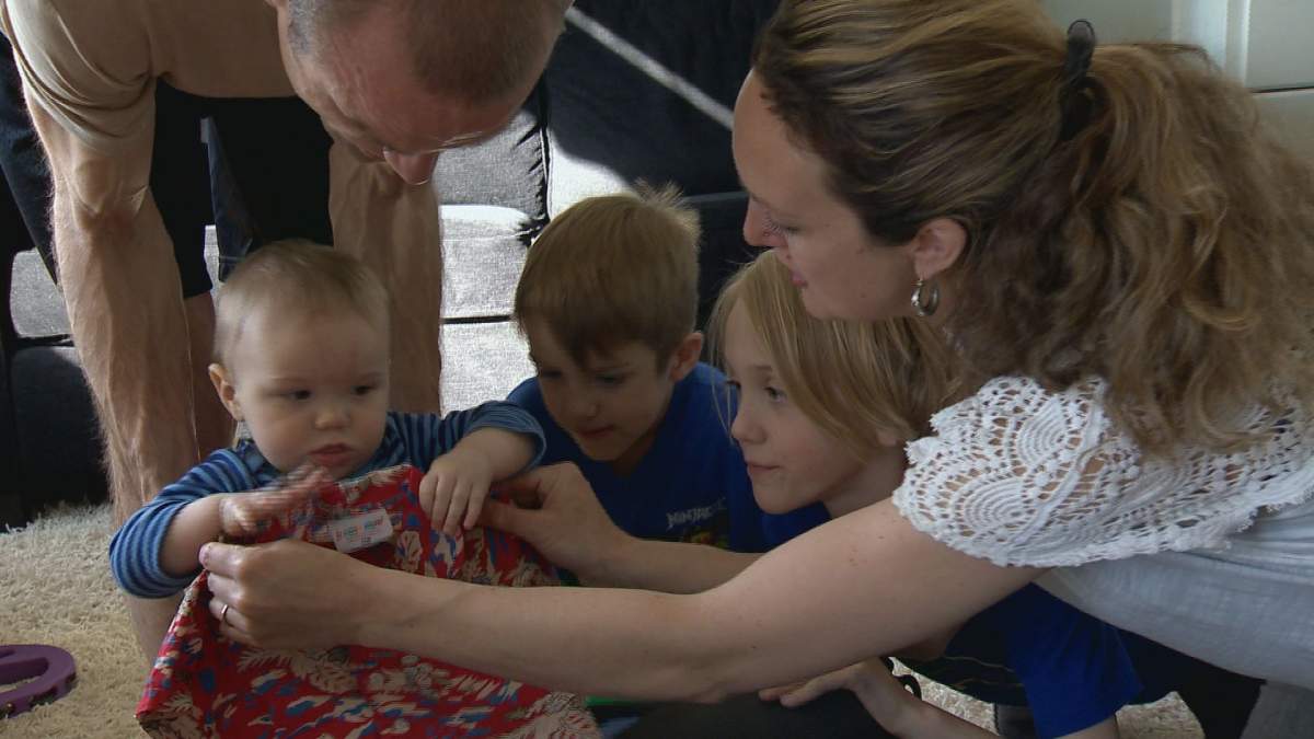 Wren Dillman sizes up his new shirt before heading to Hawaii. It will be the family’s first vacation as a party of five.