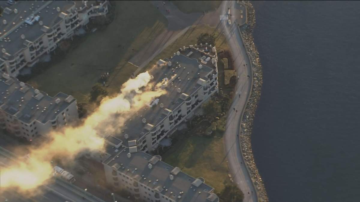 Smoke is seen pouring from a third-floor unit of an apartment building in False Creek.