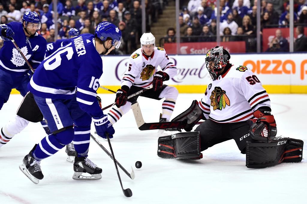 Toronto Maple Leafs right wing Mitchell Marner (16) looks to control a pass as Chicago Blackhawks goaltender Corey Crawford (50) covers his net during first period NHL hockey action in Toronto on Wednesday, March 13, 2019. THE CANADIAN PRESS/Frank Gunn.