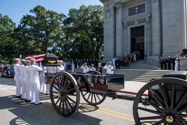 Navy Body Bearers place the casket of the late Sen. John McCain onto a horse-drawn caisson after his funeral service at the United States Naval Academy Chapel, Sept. 2, 2018.