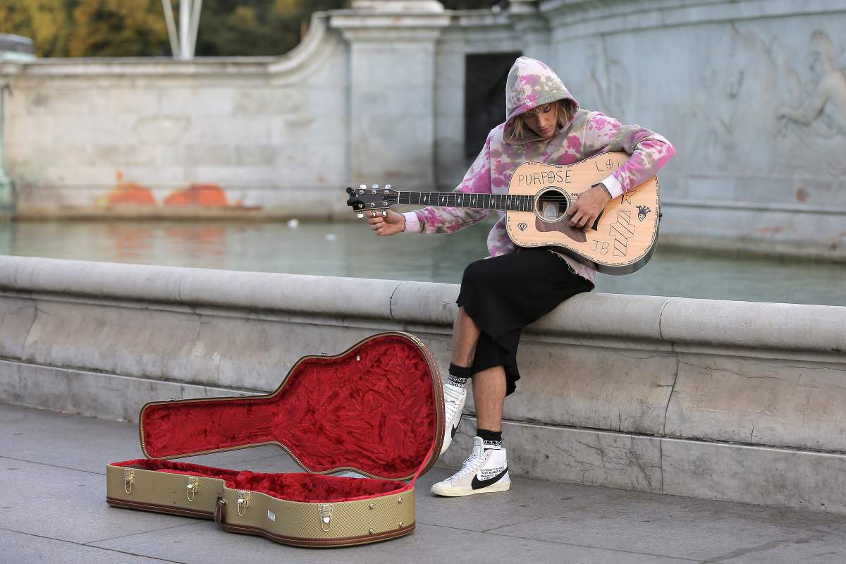 Justin Bieber stops at the Buckingham Palace fountain to play a couple of songs with his guitar for Hailey Baldwin and fans on Sept. 18, 2018, in London, England.