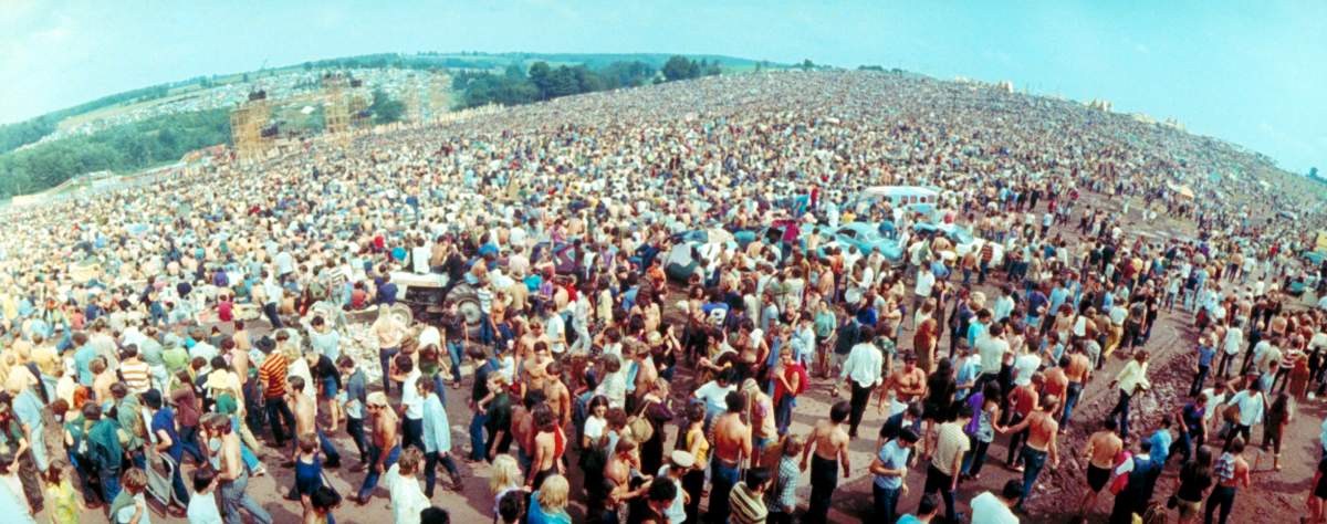 A wide-angle image of the huge crowd facing the distant stage during the Woodstock Music & Art Fair.