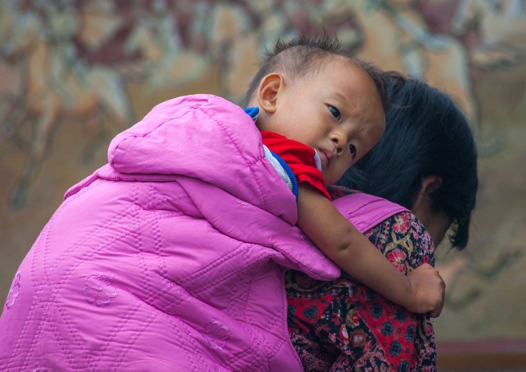 In this Sept. 11, 2008 file photo, a North Korean woman carries a boy on her back in Sariwon, North Korea.


