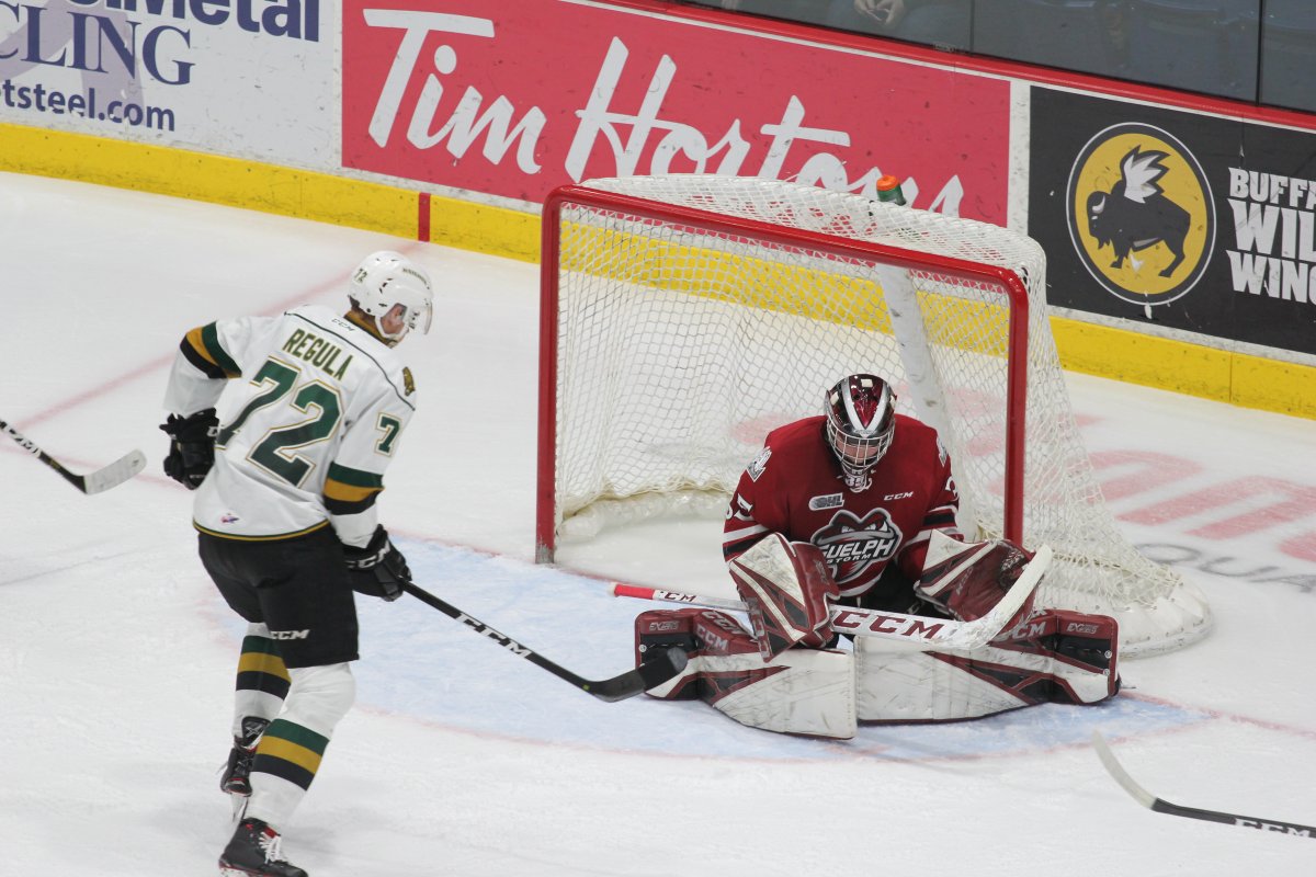 Guelph Storm goaltender Nico Daws stops a shot as Alec Regula of the London Knights looks on. The Storm defeated the Knights 5-1.