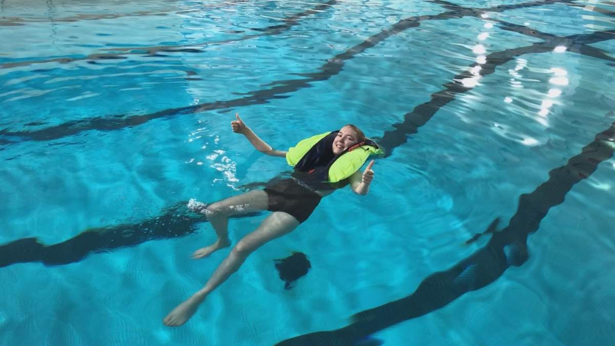 Kaitlin MacIsaac tests out the students’ prototype in the pool.