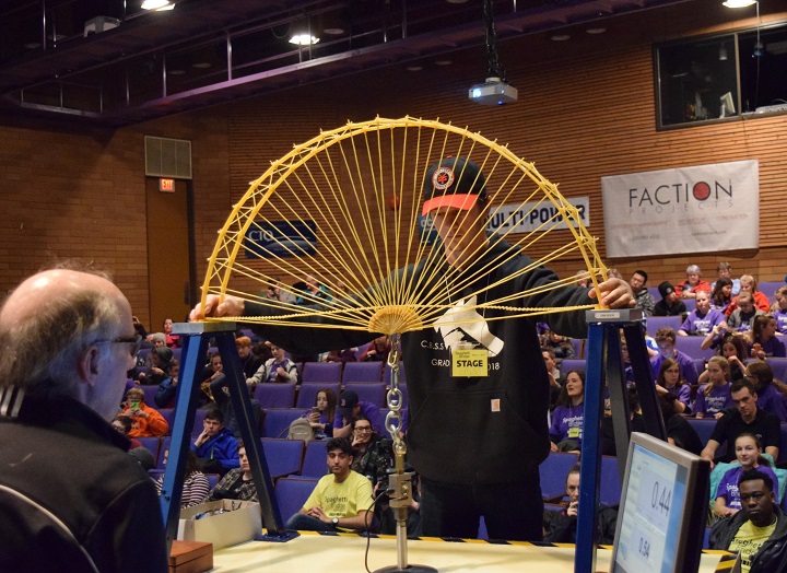 James Dessert places his bridge on the load tester at Okanagan College’s 36th annual spaghetti bridge building contest on Friday. Dessert placed first.