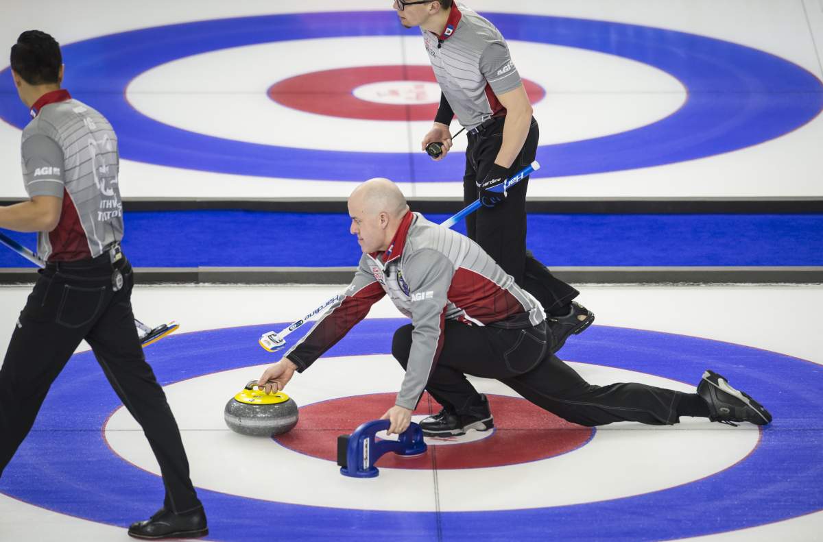 Team Northwest Territories skip Jamie Koe makes a shot as lead Cole Parsons, right, and second Matt Ng look on during the sixth draw against team Nova Scotia at the Brier in Brandon, Man. Monday, March, 4, 2019.