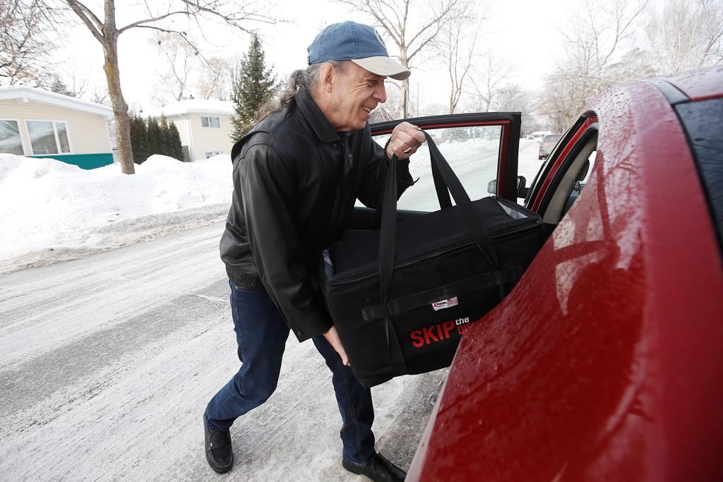 Monty Noyes, a retired photographer who is supplementing his Canadian pension income by working for the food delivery service Skip The Dishes, loads his delivery bag into his car in Winnipeg. Wednesday, March 13, 2019.