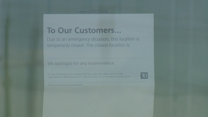 A note on the doors of the TD Canada Trust branch, stating that it was closed on Saturday morning due to an emergency situation.
