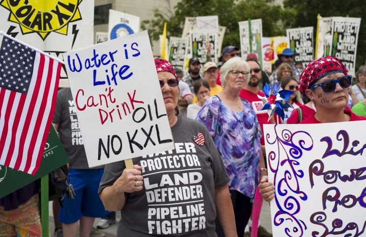 FILE - In this Aug. 6, 2017 file photo, demonstrators against the Keystone XL pipeline listen to speakers in Lincoln, Neb. Justice Department attorneys and the Canadian company behind the proposed Keystone XL oil pipeline say the U.S. government shutdown shouldn't delay a court hearing on a judge's decision to halt construction. Justice Department attorney Bridget McNeil said in a court filing Monday, Jan. 7, 20189, that federal attorneys' participation in the hearing next Monday in U.S. District Court in Great Falls isn't necessary. 
