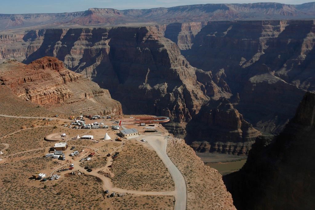 In this March 20, 2007, file photo, the Skywalk hangs over the Grand Canyon on the Hualapai Indian Reservation before its grand opening ceremony at Grand Canyon West, Ariz. Crews are searching for a tourist who slipped and fell over the edge of a Grand Canyon lookout on tribal land. The fall happened Thursday, March 28, 2019, morning on the Hualapai Tribe's reservation outside the boundaries of Grand Canyon National Park.