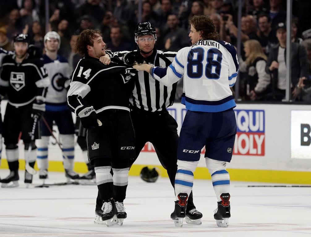 Los Angeles Kings' Brendan Leipsic, left, and Winnipeg Jets' Nathan Beaulieu (88) are separated by a referee during the second period of an NHL hockey game Monday, March 18, 2019, in Los Angeles. (AP Photo/Marcio Jose Sanchez).