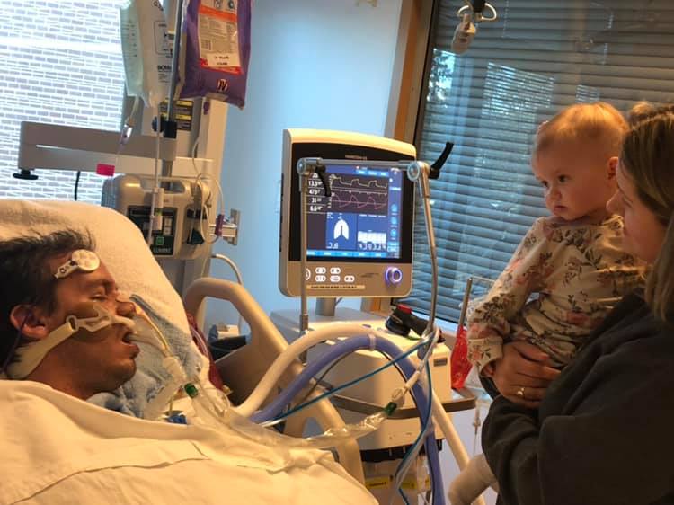 Matt Reisig has been in hospital for three weeks with a rare, paralyzing condition. Here, his wife Ashley brings their one-year-old daughter Ayla for a visit. 