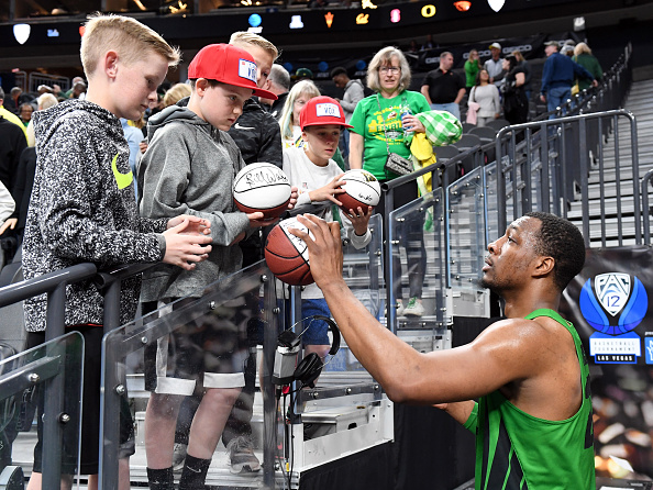 LAS VEGAS, NV - MARCH 08:  MiKyle McIntosh #22 of the Oregon Ducks autographs basketballs for fans after the Ducks defeated the Utah Utes 68-66 in a quarterfinal game of the Pac-12 basketball tournament at T-Mobile Arena on March 8, 2018 in Las Vegas, Nevada.