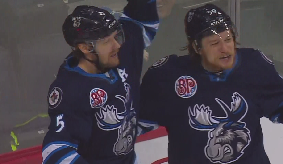 Cameron Schilling and Ryan White celebrate Manitoba's third goal of the game.