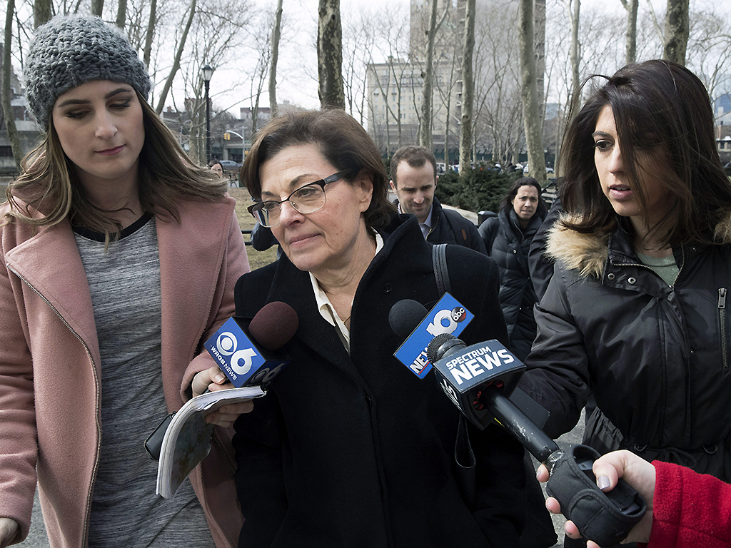 Nancy Salzman, centre, is surrounded by reporters as she arrives at Brooklyn federal court, Wednesday, March 13, 2019, in New York.