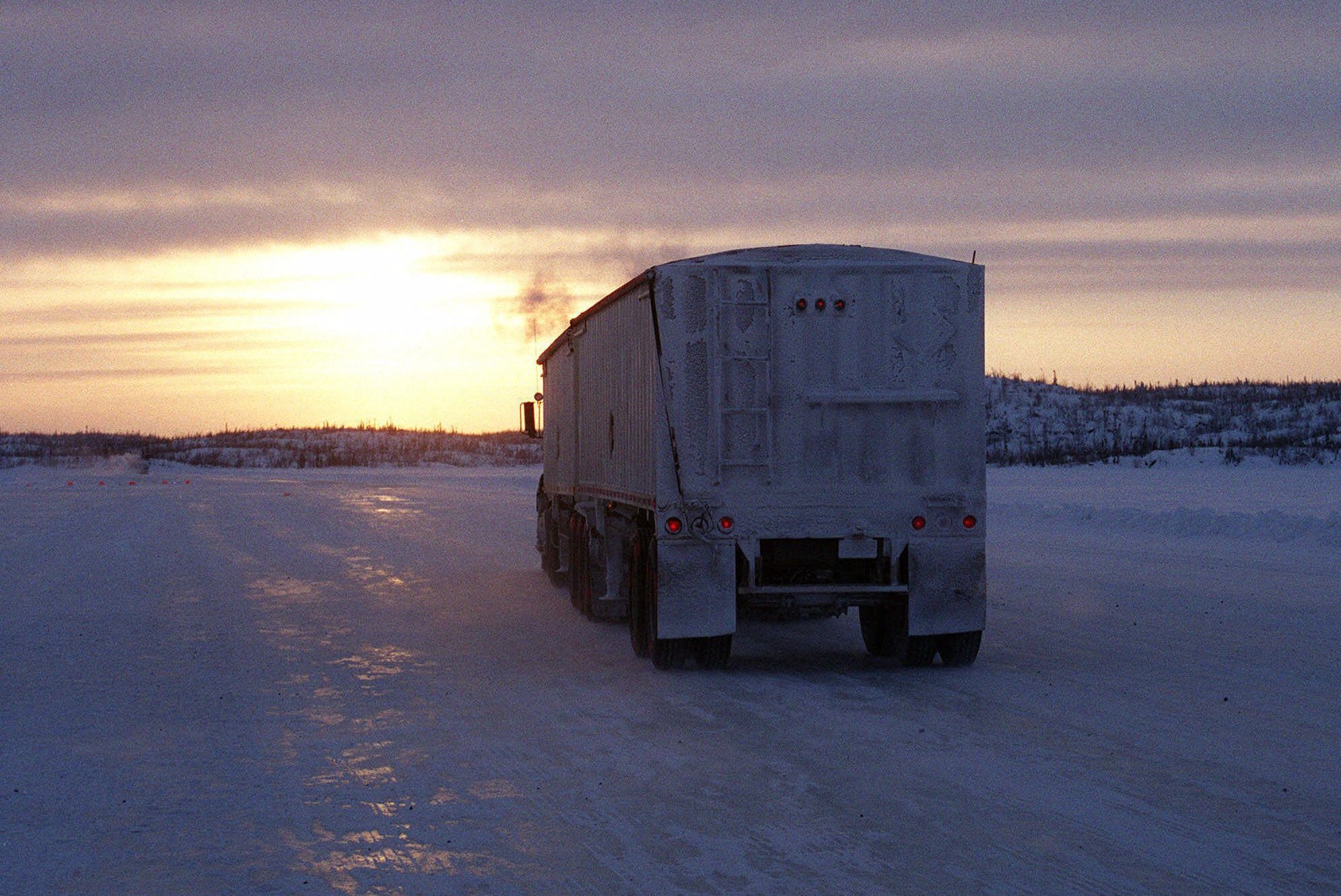 A truck heads toward the sunset on the Lupin winter road in Canada's Northwest Territories on Feb. 18, 2001. Built over frozen lakes, the Lupin ice highway exists for about three months, in the harshest season of the year, in a region that has no other roads. 