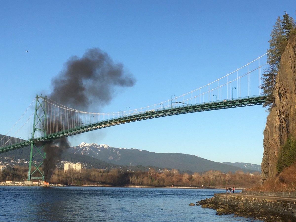A fire burning under the Lions Gate Bridge on Tuesday. 