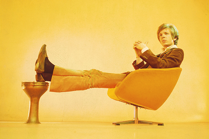 Scott Walker (Scott Engel) sitting on a 1960s chair during his solo era.
