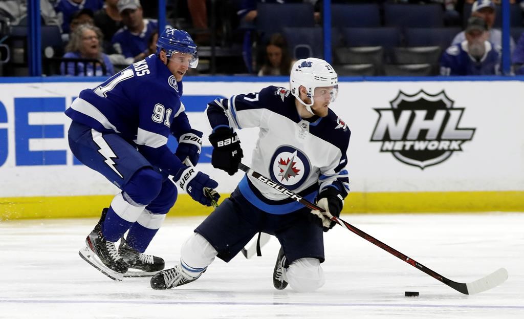 Winnipeg Jets left wing Nikolaj Ehlers (27) plays the puck from his knees after getting taken down by Tampa Bay Lightning center Steven Stamkos (91) during the second period of an NHL hockey game Tuesday, March 5, 2019, in Tampa, Fla. (AP Photo/Chris O’Meara)