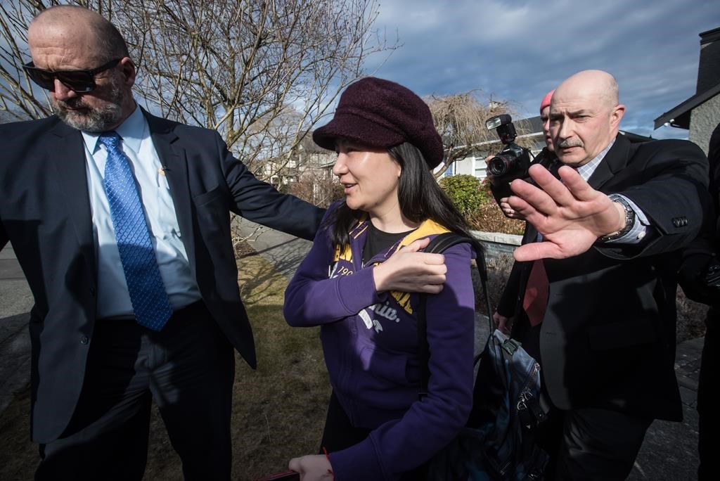 Huawei chief financial officer Meng Wanzhou, centre, who is out on bail and remains under partial house arrest after she was detained Dec. 1 at the behest of American authorities, is accompanied by a private security detail as she leaves her home to attend a court appearance in Vancouver, on Wednesday March 6, 2019.