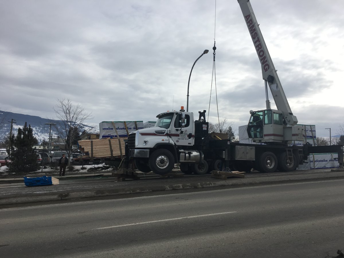A crane has been brought in to offload lumber from a semi that partially lost its load Wednesday morning on Highway 97 adjacent to Vernon Jubilee Hospital.