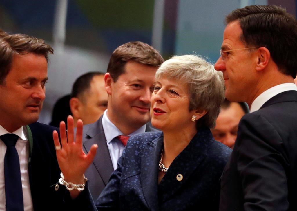 British Prime Minister Theresa May, center, speaks with Dutch Prime Minister Mark Rutte, right, and Luxembourg's Prime Minister Xavier Bettel, left, during a round table meeting at an EU summit in Brussels, Thursday, March 21, 2019. British Prime Minister Theresa May is trying to persuade European Union leaders to delay Brexit by up to three months, just eight days before Britain is scheduled to leave the bloc. (AP Photo/Frank Augstein).