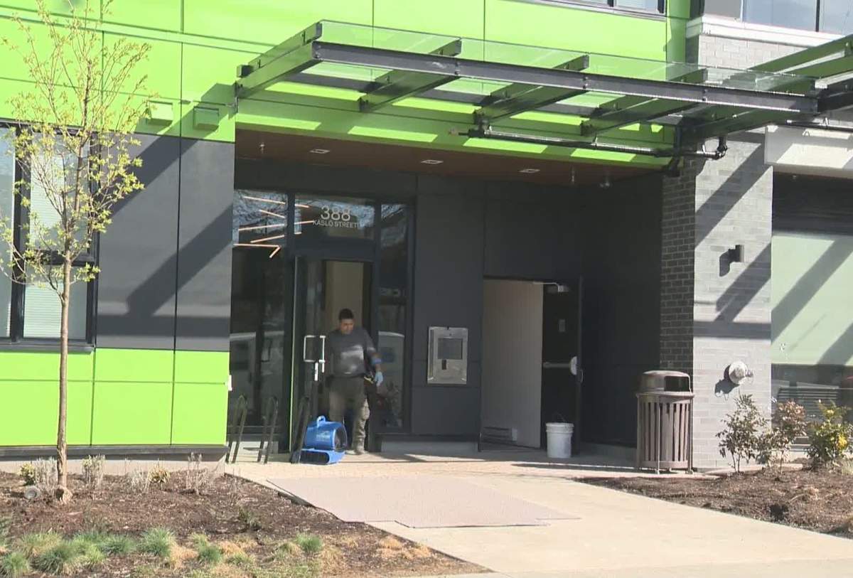 Workers bring equipment into an apartment building at 388 Kaslo Street in response to a massive flood from a standpipe early Thursday morning.