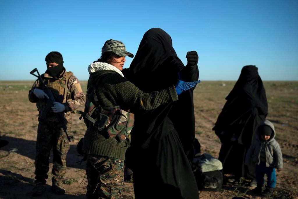 A woman is frisked by a U.S.-backed Syrian Democratic Forces (SDF) fighter at a screening area after being evacuated out of the last territory held by Islamic State militants, in the desert outside Baghouz, Syria, on March 1, 2019. (AP Photo/Felipe Dana)