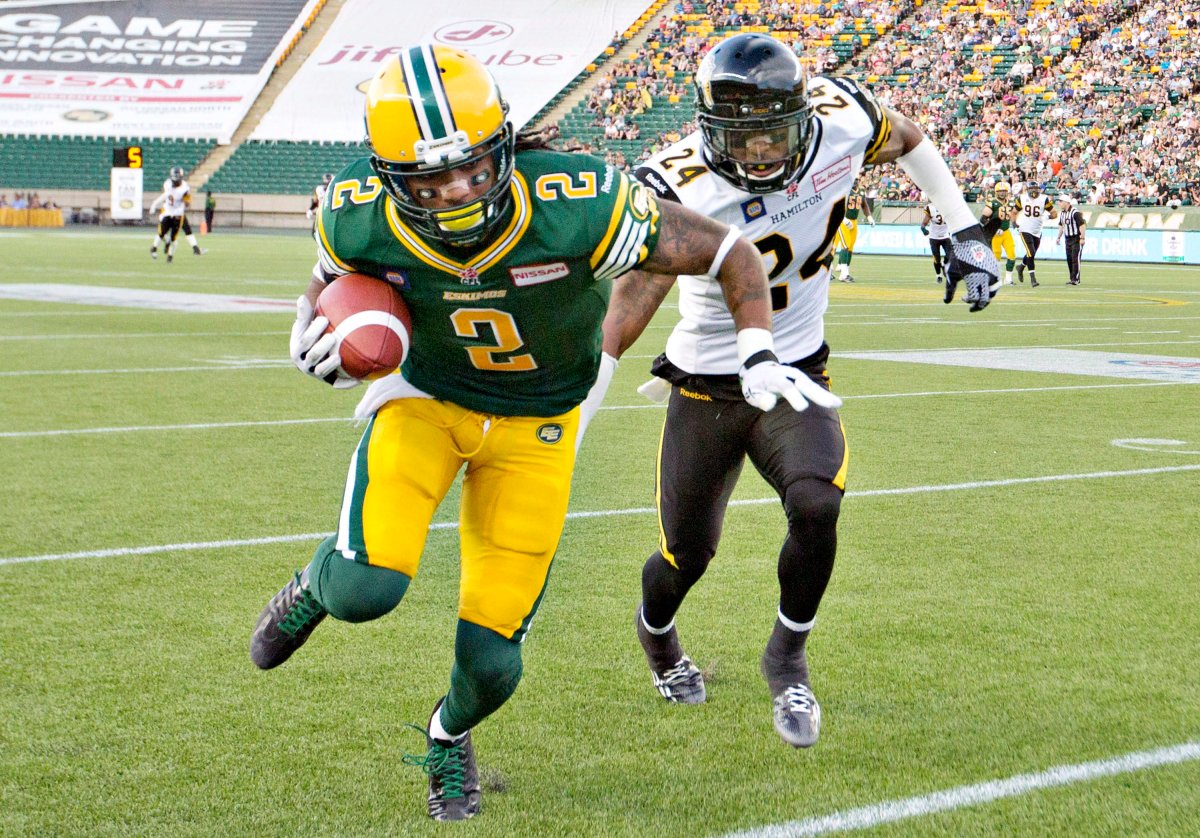 Hamilton Tiger-Cats Michael Coe (24) chases Edmonton Eskimos Fred Stamps (2) during first half action in Edmonton, Alta., on Friday July 4, 2014. 