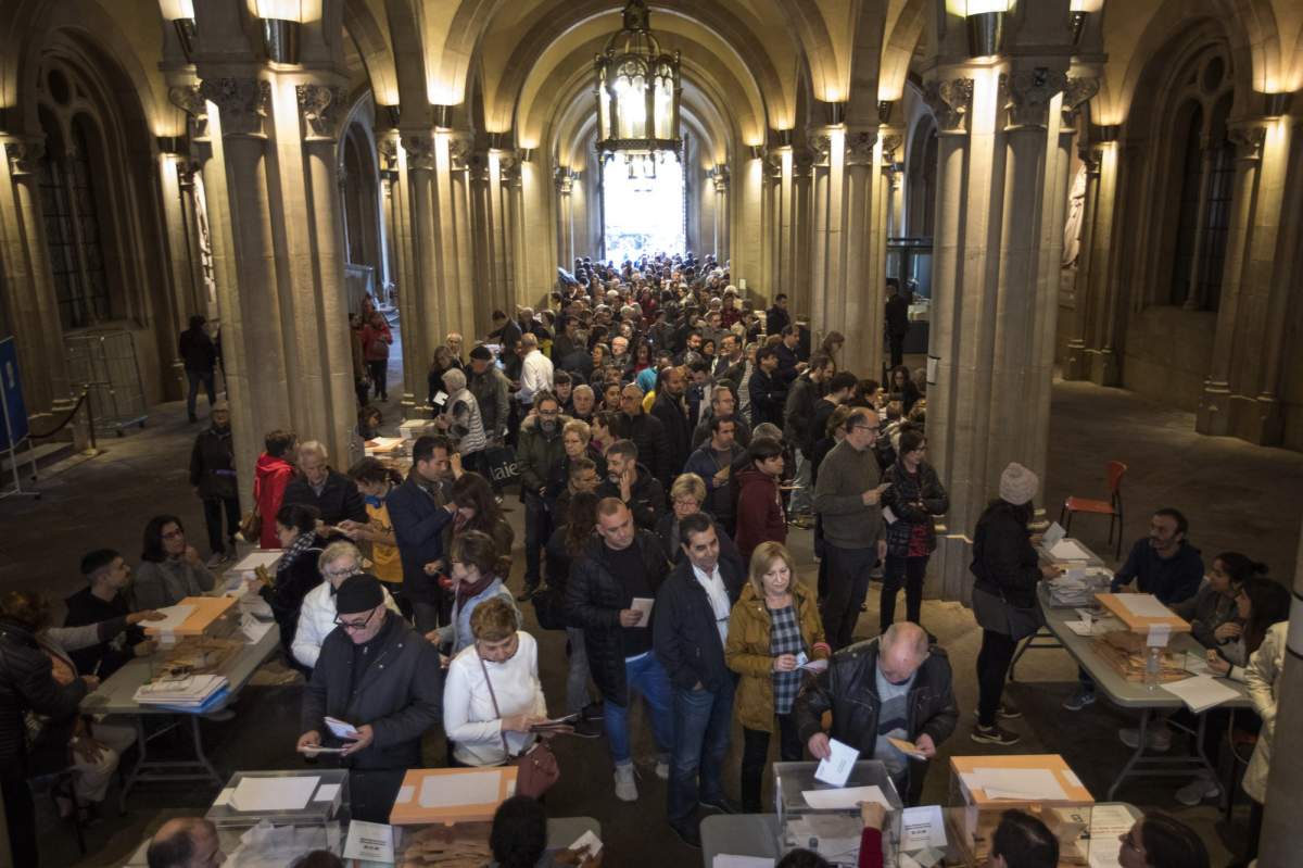 People cast their votes during Spain's general election in a polling station in Barcelona, Spain, Sunday, April 28, 2019. Voting is underway in more than 23,000 polling stations across Spain in a highly disputed general election that is likely to usher in the far-right into the national parliament. 