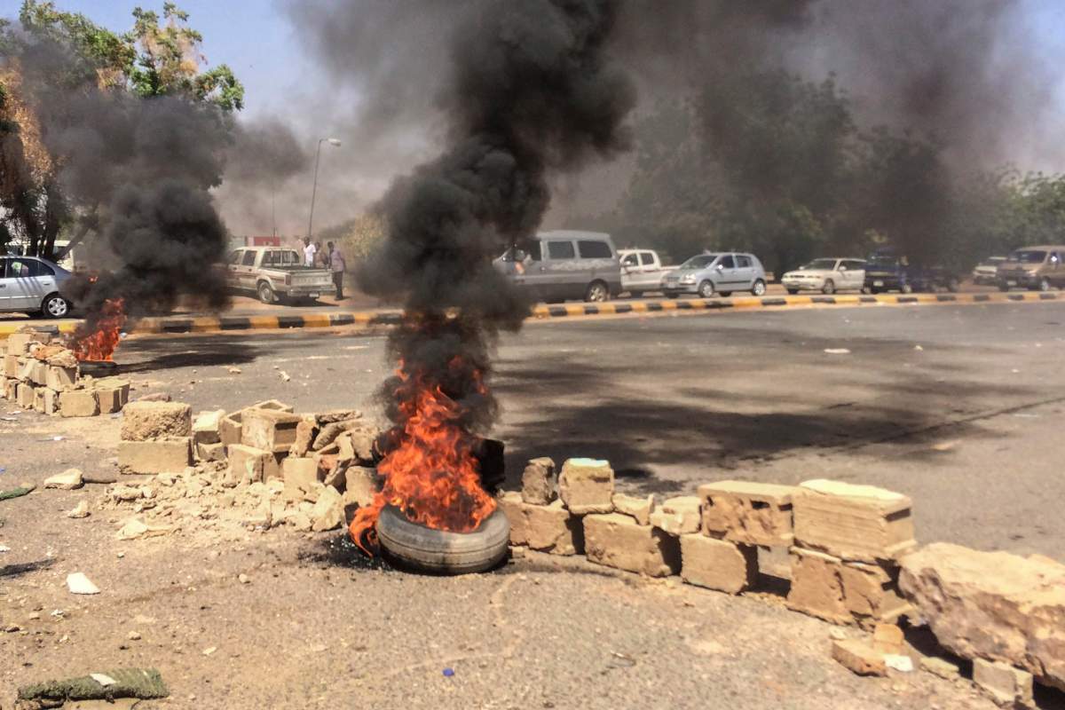 Tires lit by protesters burn near the military headquarters, Sunday, April 7, 2019, in the capital Khartoum, Sudan. Organizers behind anti-government demonstrations in Sudan said Sunday that security forces have killed at least five protesters in the last twenty-four hours.