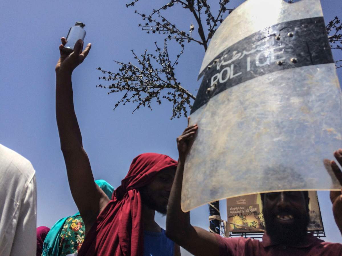 A protester holds up a police shield at a rally in front of the military headquarters in the capital Khartoum, Sudan, Monday, April 8, 2019. Organizers behind anti-government demonstrations in Sudan said security forces attempted to break up a sit-in outside the military headquarters.