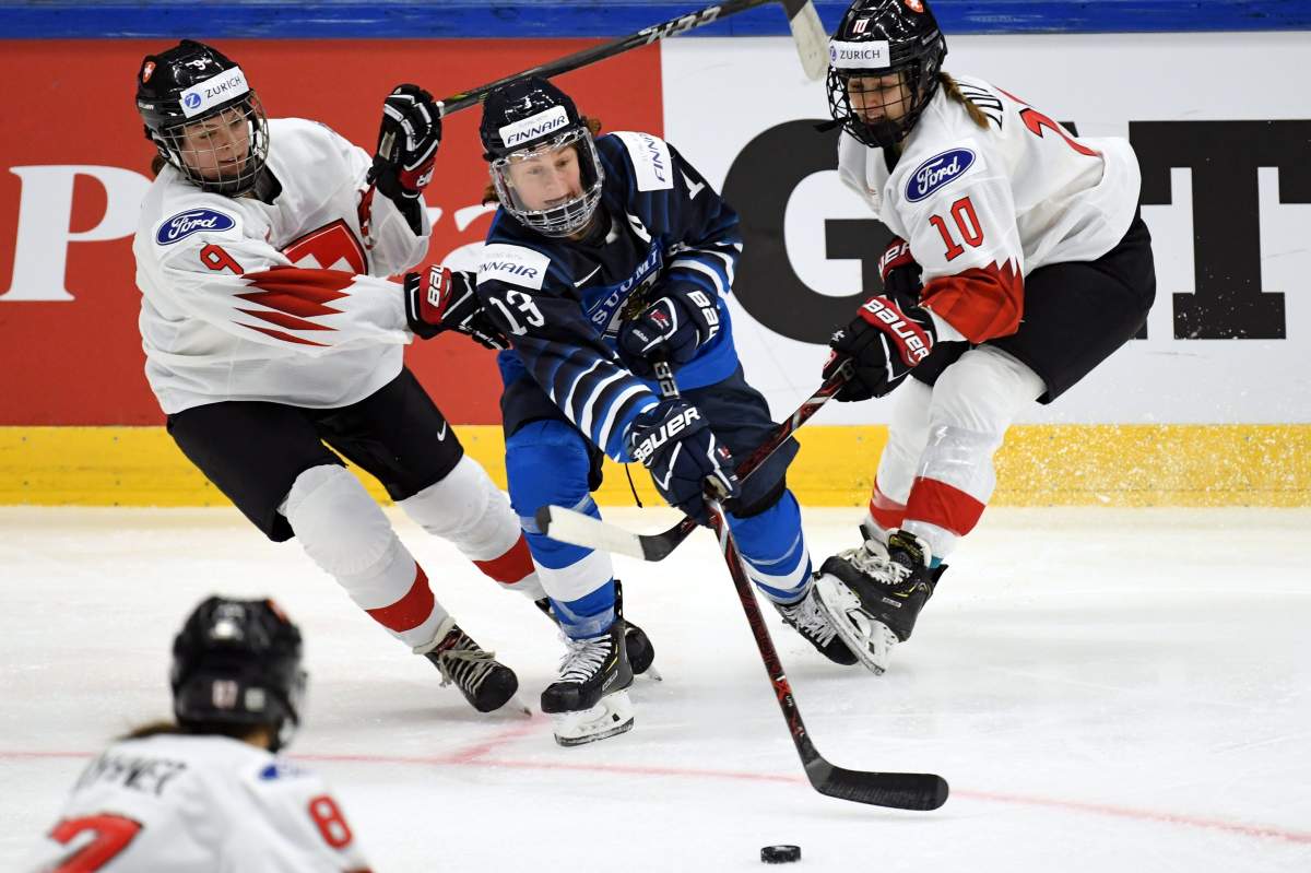 Shannon Sigrist (L) and Sabrina Zollinger of Switzerland pin Riikka Sallinen (C) of Finland during the IIHF Women’s Ice Hockey World Championships Group A match Finland vs Switzerland in Espoo, Finland on April 8, 2019.  LEHTIKUVA / ANTTI AIMO-KOIVISTO