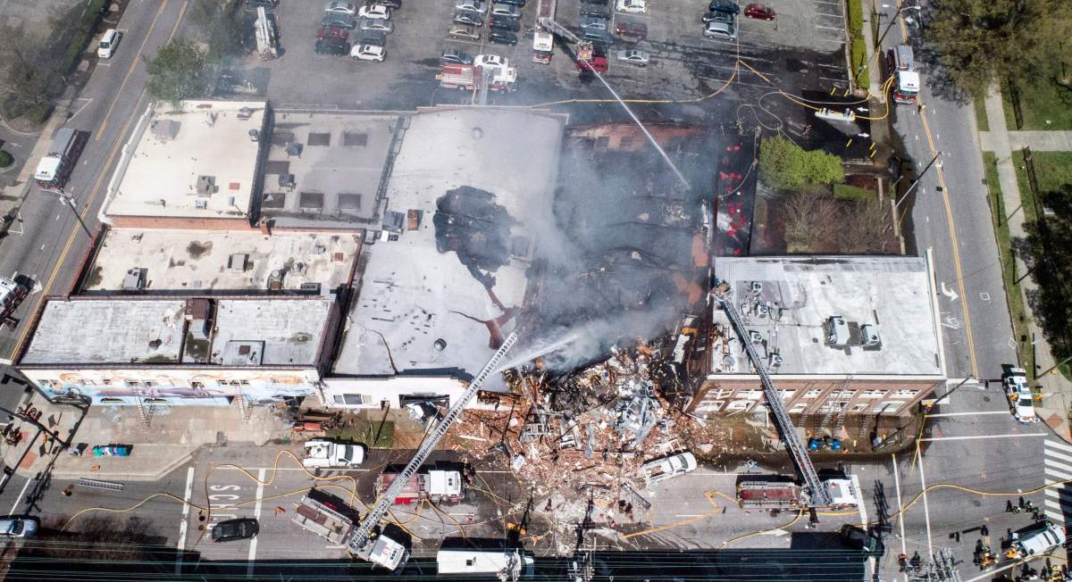 In this aerial photo, firefighters battle a fire at the scene of an explosion in Durham, N.C. Wednesday, April 10, 2019.