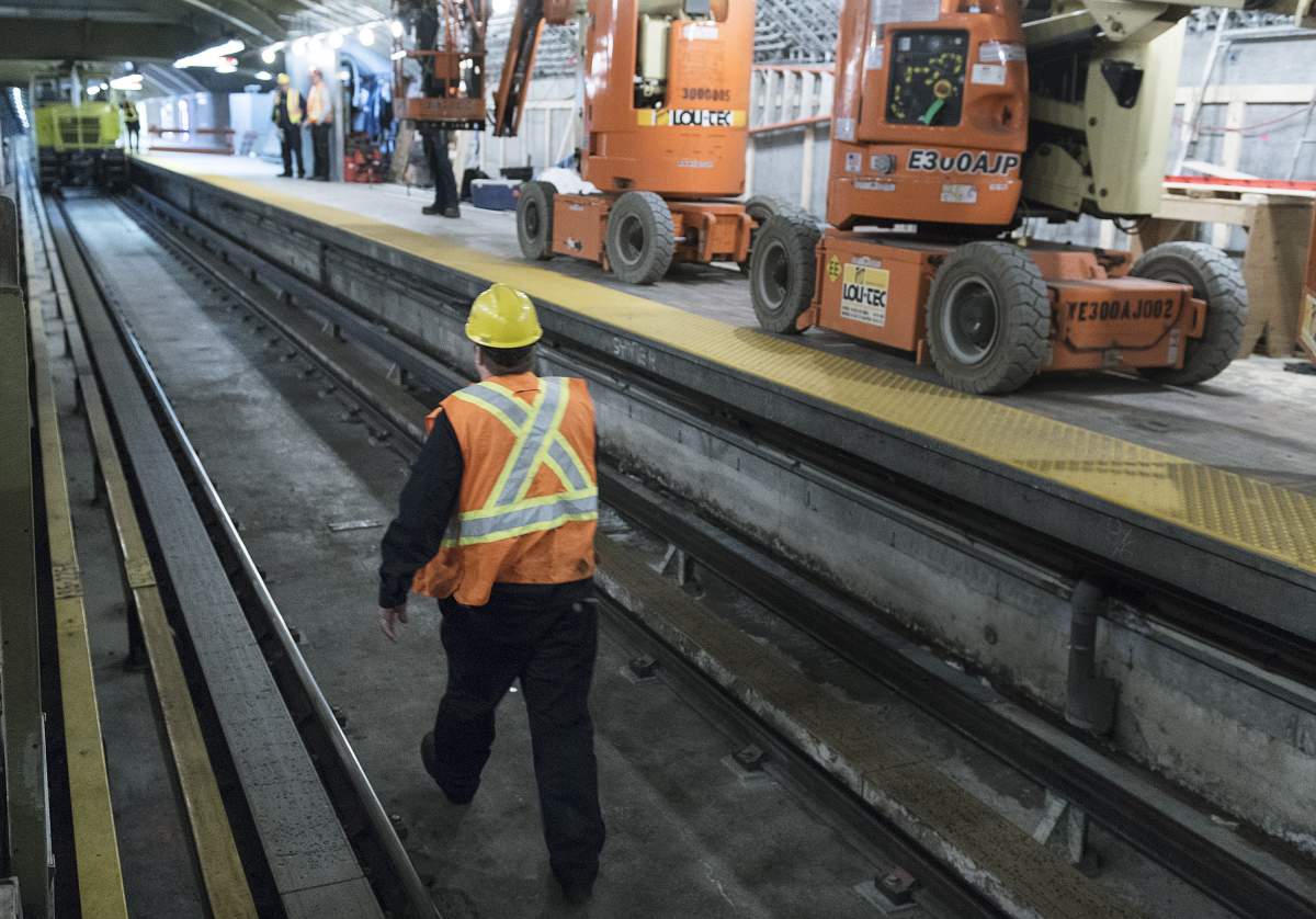 A Montreal Metro maintenance worker walks along a track during the early hours of the morning in Montreal, Thursday, April 11, 2019.