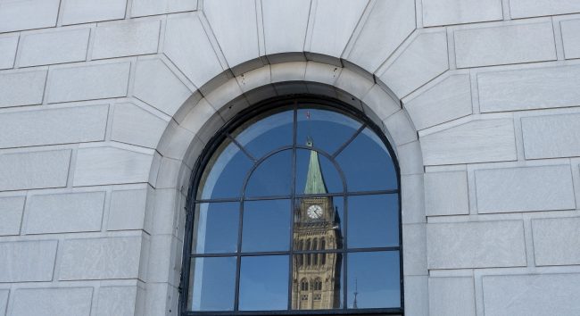The Peace tower is reflected in a window in Ottawa, Tuesday March 26, 2019. 

