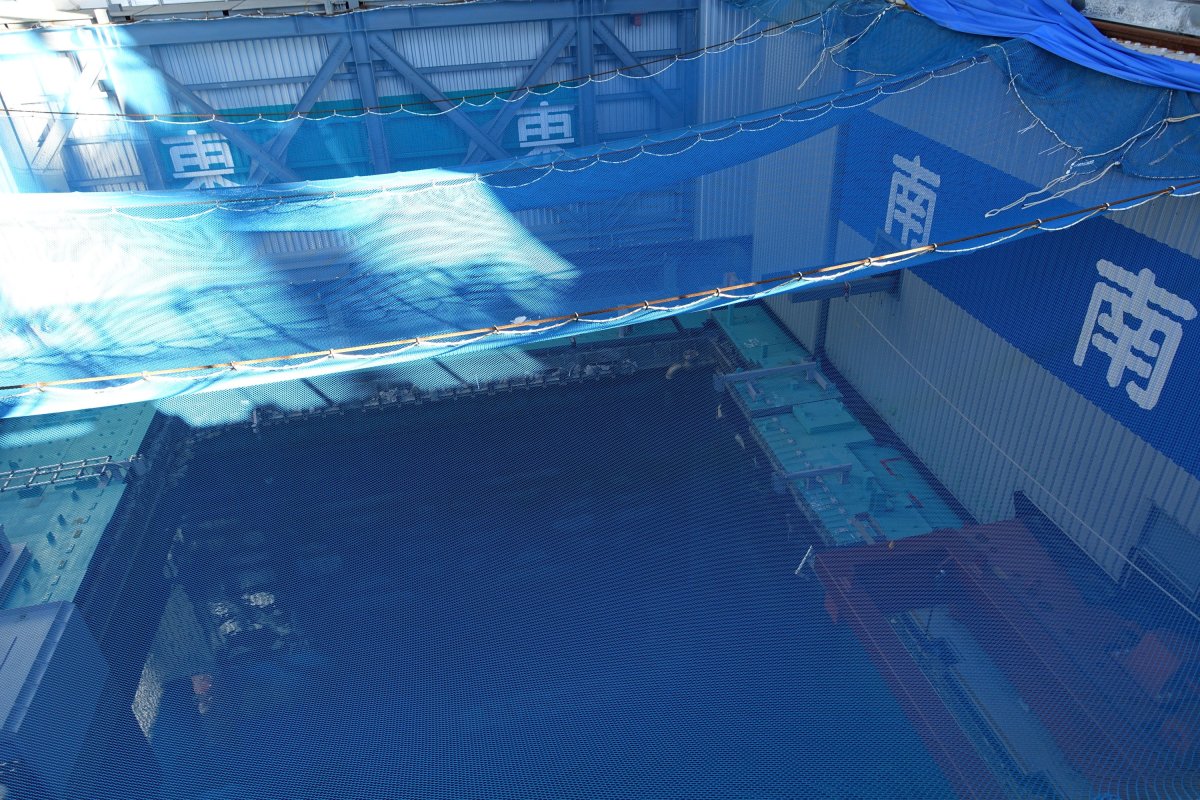 FILE - In this Jan. 25, 2018, file photo, a cooling pool where a total of mostly used 566 sets of fuel rods are stored underwater and covered by a protective net, waits to be removed in a step to empty the pool at Unit 3 of the Fukushima Dai-ichi nuclear power plant ahead of a fuel removal from its storage pool in Okuma, Fukushima Prefecture, northeast Japan.