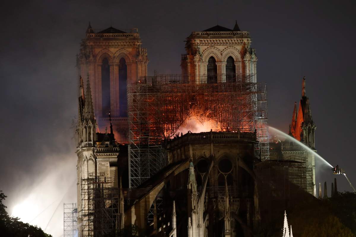 People watch Notre Dame Cathedral burning in Paris, Monday, April 15, 2019.