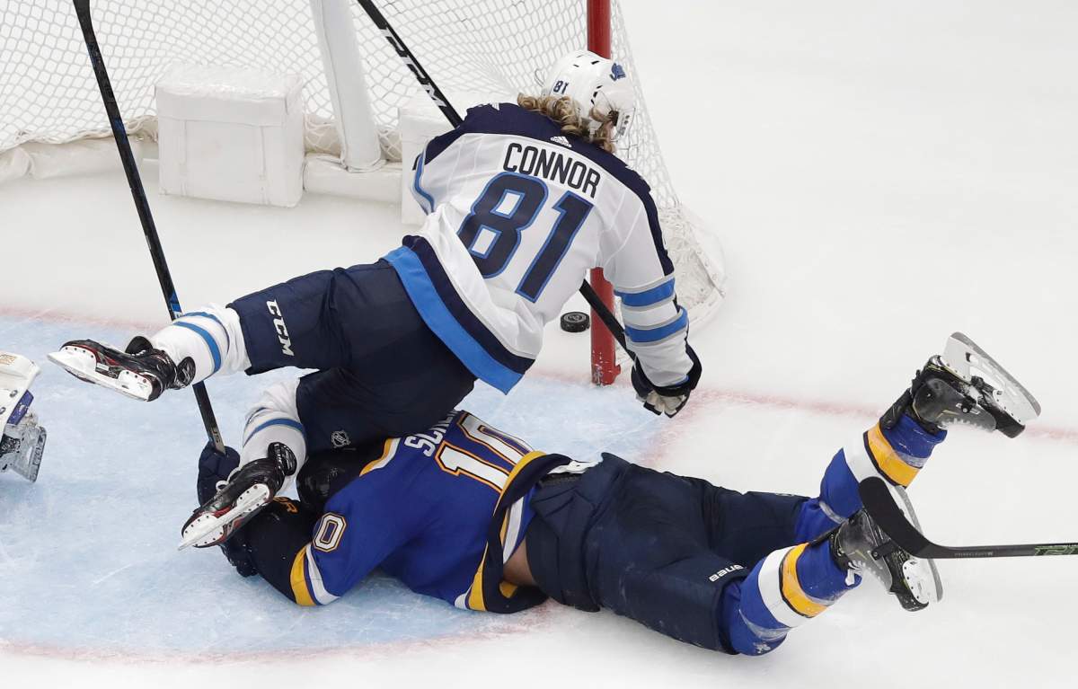 Winnipeg Jets left wing Kyle Connor (81) falls over St. Louis Blues center Brayden Schenn (10) as Connor scores during overtime in Game 4 of an NHL hockey first-round playoff series Tuesday, April 16, 2019, in St. Louis. The Jets won 2-1 to even the series 2-2. (AP Photo/Jeff Roberson)
