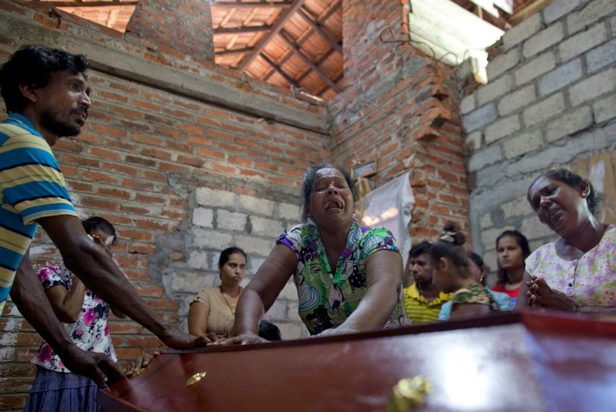Lalitha, center, weeps beside the coffin with the remains of 12-year old niece, Sneha Savindi, who was a victim of Easter Sunday bombing at St. Sebastian Church, after it returning home in Negombo, Sri Lanka, Monday, April 22, 2019.