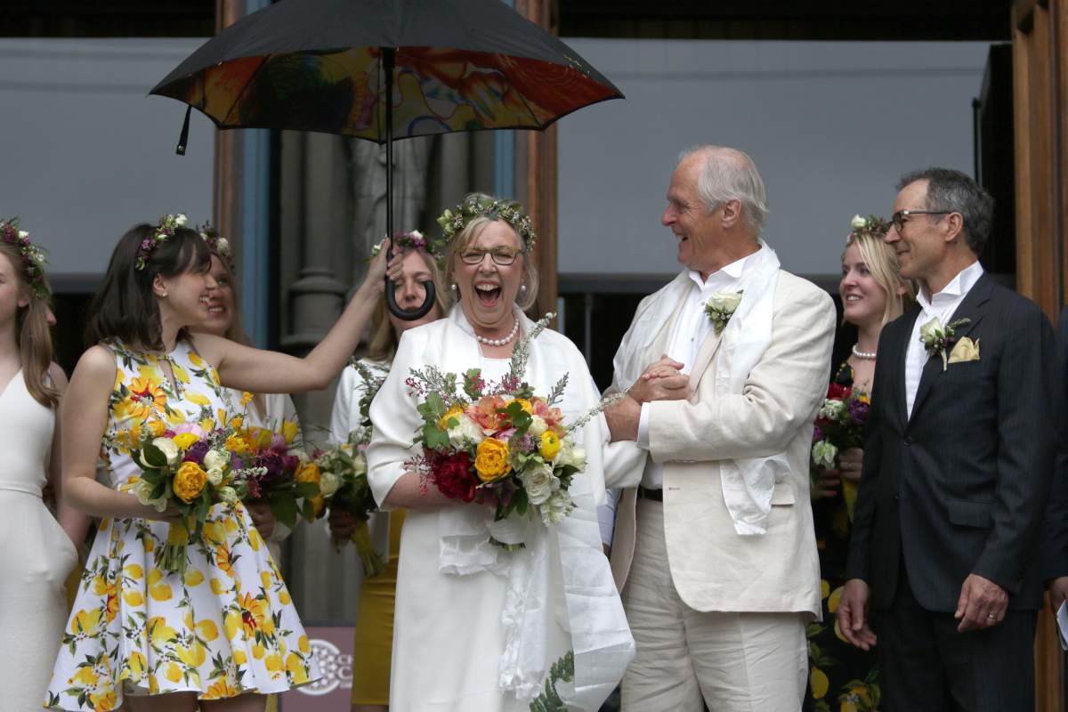 Federal Green Party leader Elizabeth May and her husband John Kidder greet the crowd as her daughter Cate holds an umbrella following their marriage during Earth Day at the Christ Church Cathedral in Victoria, B.C., on Monday, April 22, 2019.