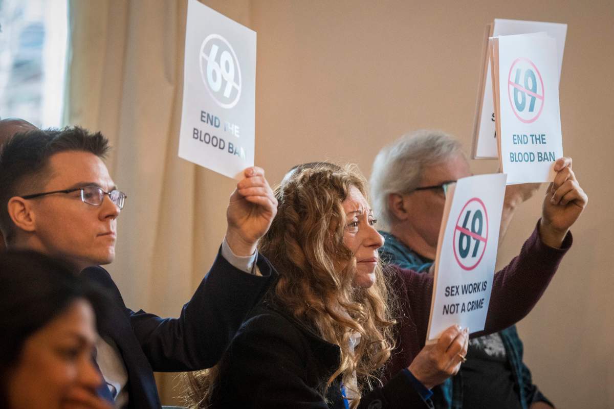 Protesters at an event unveiling the new LGBTQ2 loonie in Toronto on Tuesday, April 23, 2019.