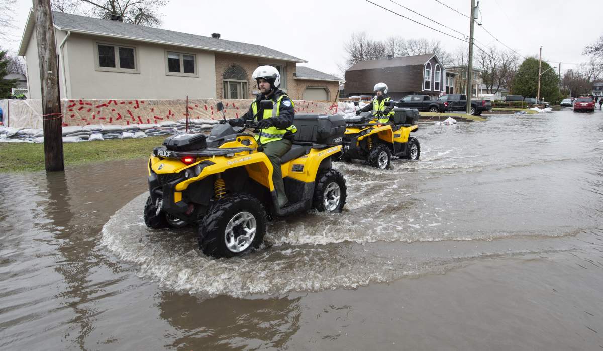 Police patrol a flooded neighbourhood on Ile Bizard, Que., on Wednesday, April 24, 2019.
