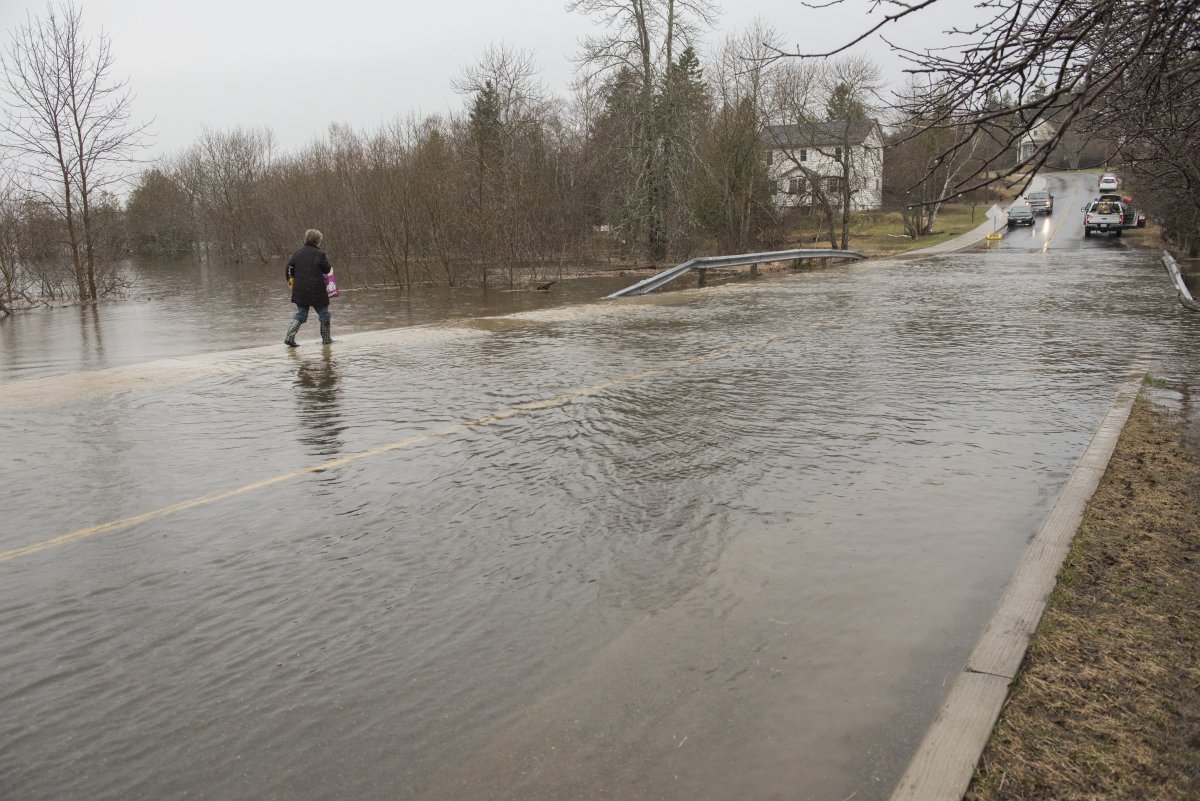 A woman wades through the flood waters of the St. John River on the only access road to the Dominion Park community in Saint John, N.B., on Wednesday, April 24, 2019.