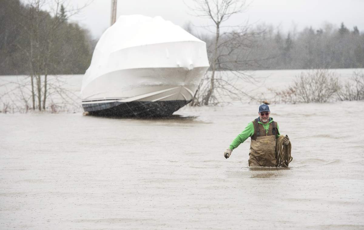 Mark Palmer wades through the flood waters of the St. John River after tying his brother’s boat to the pole behind it so it wouldn’t float away as the water continues to rise in Saint John, N.B., on Wednesday, April 24, 2019.