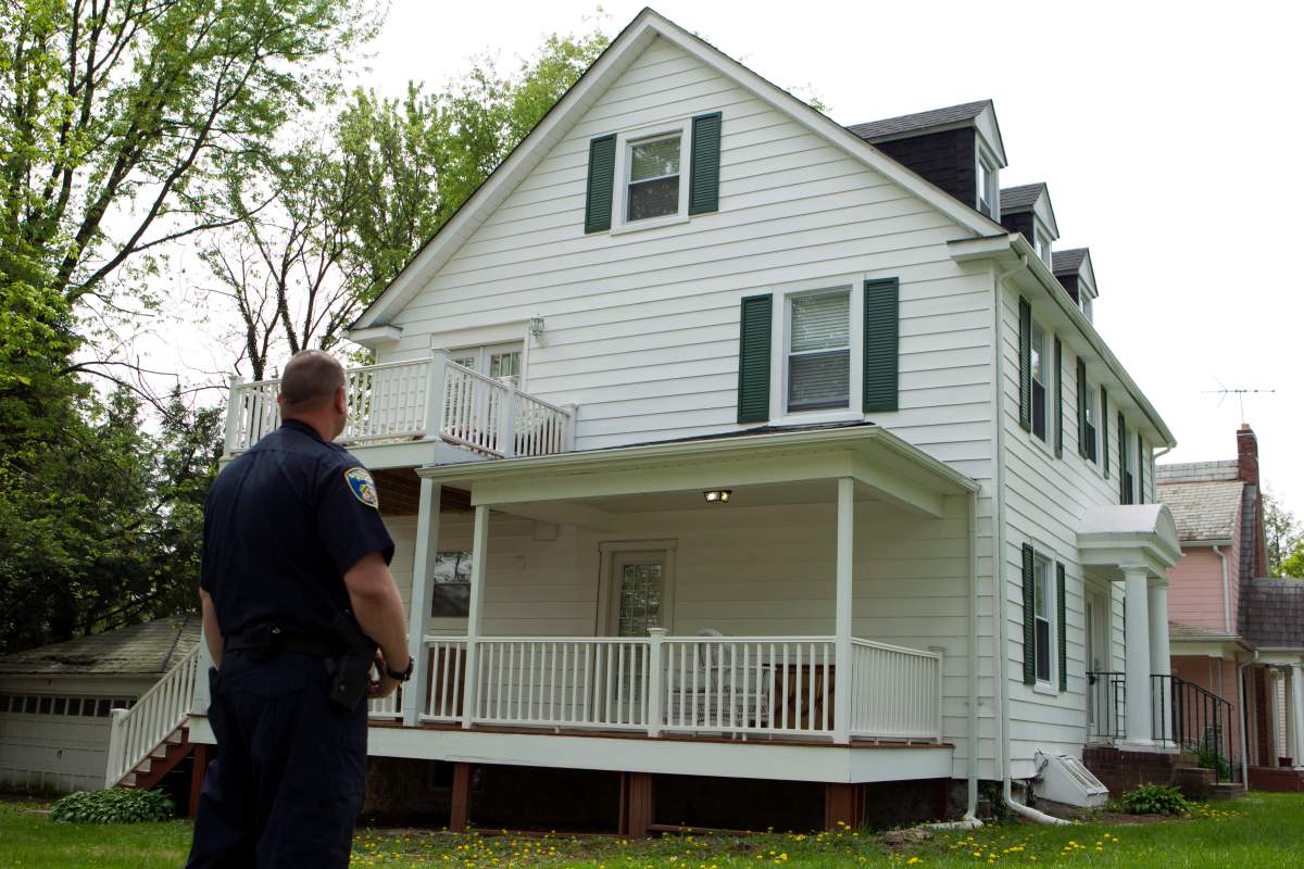A Baltimore police officer stands outside the house of Baltimore Mayor Catherine Pugh in Baltimore, Md., Thursday, April 25, 2019. Agents with the FBI and IRS are gathering evidence inside the two homes of Pugh and also in city hall.